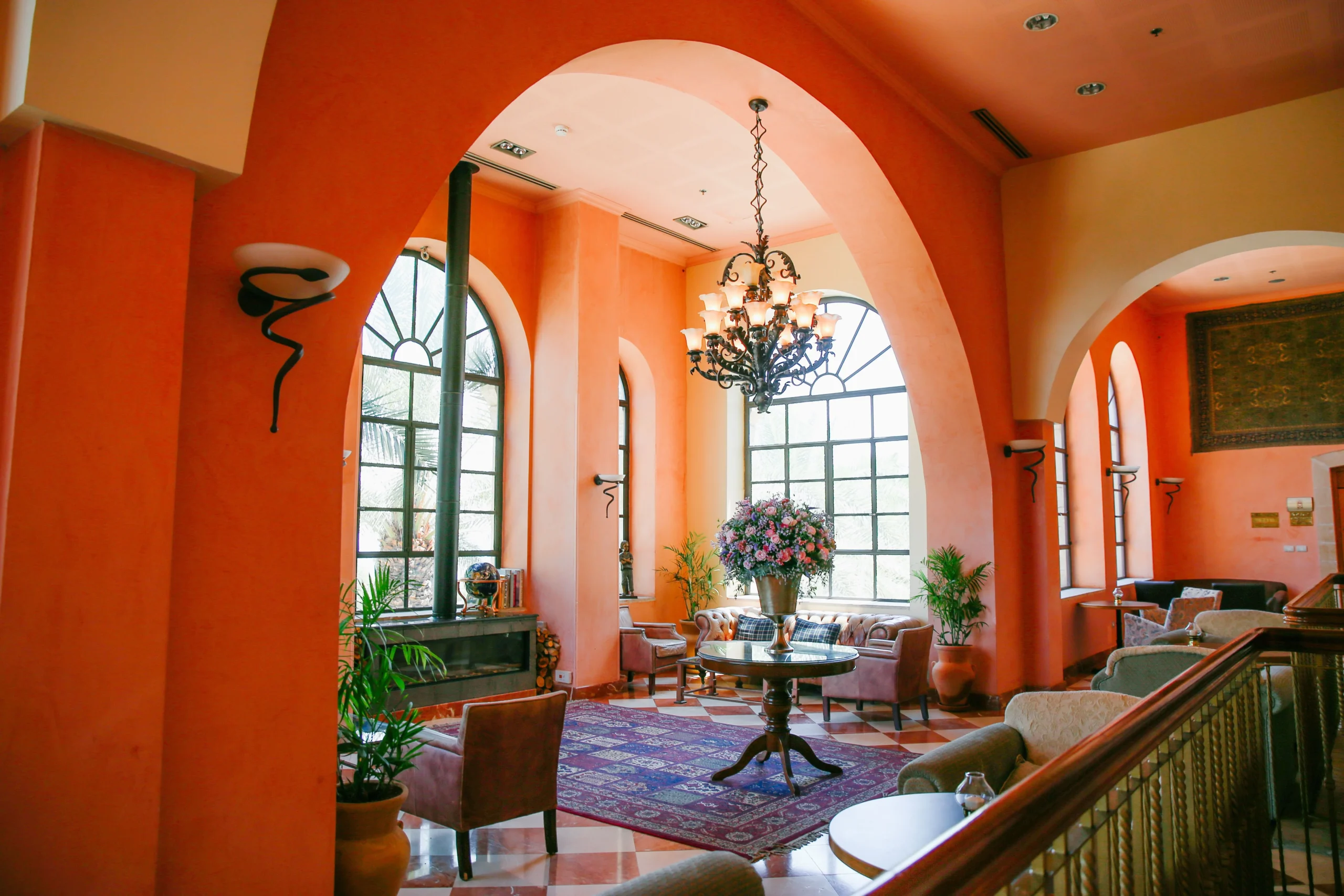 Mediterranean living room with terracotta walls, arched windows and traditional decor